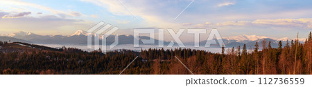 Spring dusk Carpathian mountains landscape with snow-covered ridges in far, Ukraine. From left to right - Hoverla, Petros, Blyznycja tops. Spring dusk Carpathian mountains landscape with snow-covered ridges in far, Ukraine. From left to right - Hoverla, Petros, Blyznycja tops. 112736559