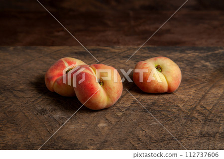 Three saturn peaches or flat peach on wooden background.. Three saturn peaches or flat peach on wooden background.. 112737606