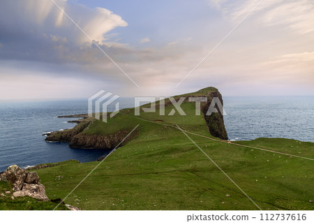 Neist Cliff in Isle of Skye showcases landscape of green slopes descending into the vast sea 112737616