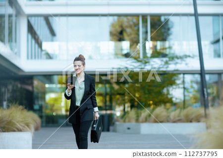 smiling woman employee in business district walking smiling woman employee in business district walking 112737795