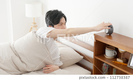 man stopping alarm clock man stopping alarm clock 112738387