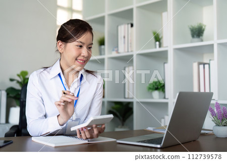 Finance concept. businesswoman Press the calculator to calculate finances, and memo, and analyzing business documents with a laptop computer 112739578