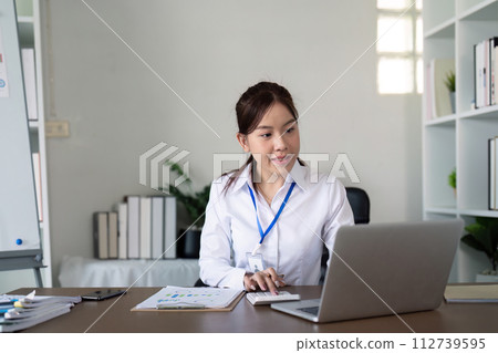 Asian business woman using laptop to analysis graph financial budget report and planning for future in office desk Asian business woman using laptop to analysis graph financial budget report and planning for future in office desk 112739595