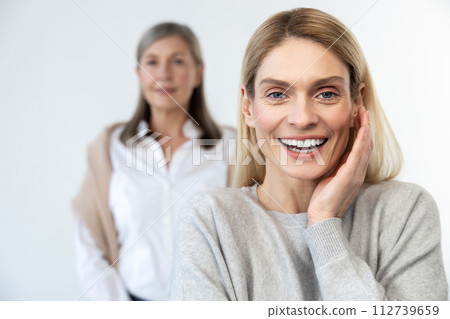Blonde woman and her mom looking contented and confident Blonde woman and her mom looking contented and confident 112739659