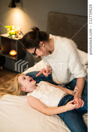 Happy little girl with lovely mother having fun in bedroom together Happy little girl with lovely mother having fun in bedroom together 112739826