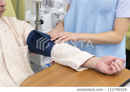 Female nurse measuring blood pressure of elderly people Female nurse measuring blood pressure of elderly people 112740326