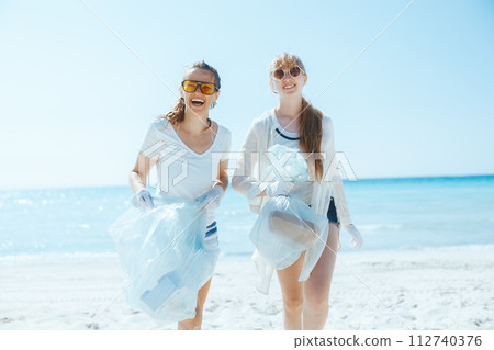 happy environment activists on ocean shore collecting trash happy environment activists on ocean shore collecting trash 112740376