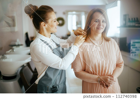 woman hair salon worker in modern beauty studio with client woman hair salon worker in modern beauty studio with client 112740398