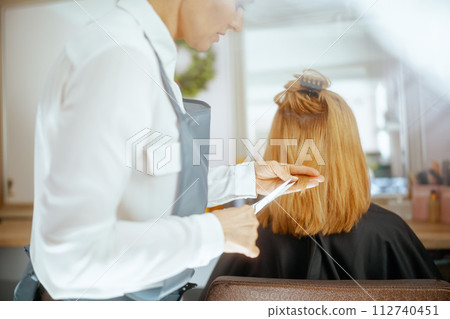 woman hairdresser in hair studio cutting hair woman hairdresser in hair studio cutting hair 112740451