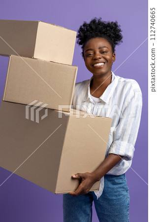 Dark-skinned young woman with boxes in hands looking contented 112740665