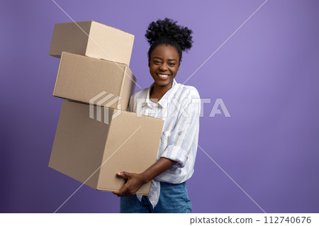 Dark-skinned young woman with boxes in hands looking contented 112740676