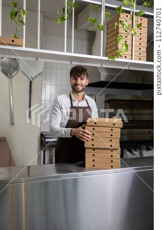 Bearded man cafe employee holding stack of pizza boxes 112740701