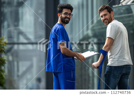 Brunette male nurse and his patient having a walk together 112740736
