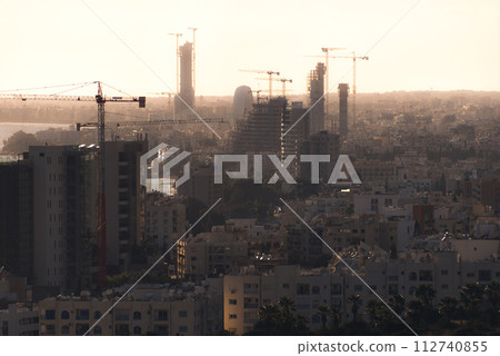 Silhouettes of high-rise buildings under construction in evening. Limassol, Cyprus Silhouettes of high-rise buildings under construction in evening. Limassol, Cyprus 112740855