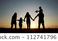 family walks across the field. happy childhood concept for little child. big happy family walks across the field on the grass holding hands, sunset on the background, silhouettes lifestyle 112741796