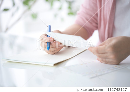 Hand of a middle-aged woman writing a letter 112742127