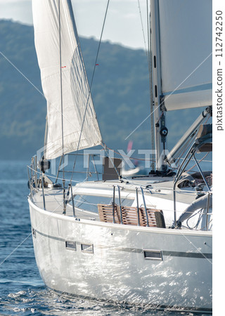 Rear view of Sailing yacht with white sails in the sea Rear view of Sailing yacht with white sails in the sea 112742250