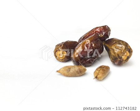 Dates and date seeds on a white background. 112743182