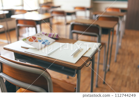 Textbooks and notebooks placed on classroom desks Textbooks and notebooks placed on classroom desks 112744249