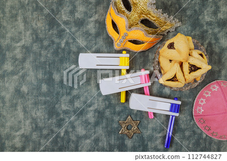 Rattles, carnival masks, hamantaschen cookies are symbols of Jewish holiday Purim. 112744827