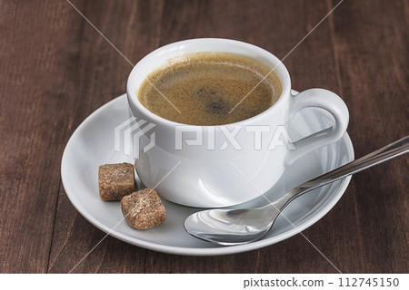 White cup of coffee and sugar on a dark wooden background 112745150