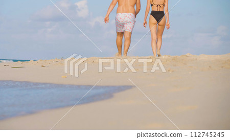 Couple walk on beach. 112745245