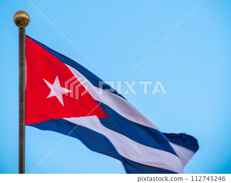 CUBA flag waving with a cloudy blue sky. Large flag in the heart of Cuba, Havana 112745246