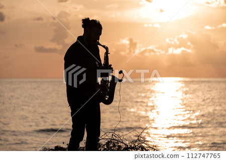 Man playing the Saxophone at sunset 112747765