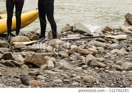 People are preparing for rafting. The athlete is waiting for the team on the bank of the river. People are preparing for rafting. The athlete is waiting for the team on the bank of the river. 112748285