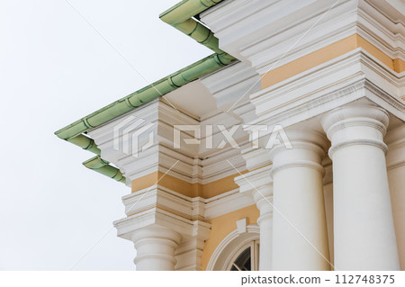 Classical portico with yellow and white details under green roof Classical portico with yellow and white details under green roof 112748375