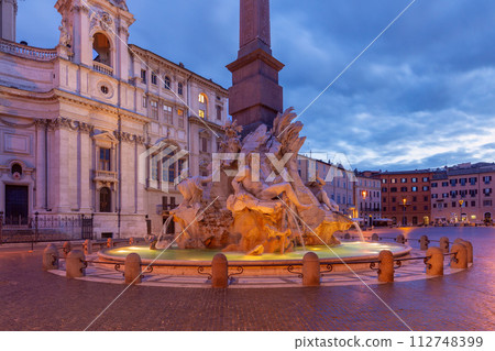 The famous fountains with tritons in Piazza Navona in Rome at dawn. 112748399
