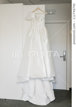 the bride's wedding dress hangs on the closet in the morning room the bride's wedding dress hangs on the closet in the morning room 112748740