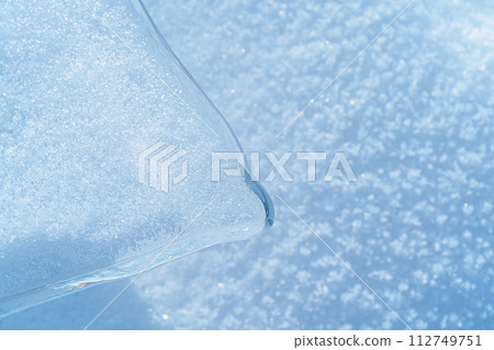Ice hummocks covered in snow on Baikal Lake. Transparent blue ice floe. Natural background. Great backdrop for your design with copy space. Top view. 112749751
