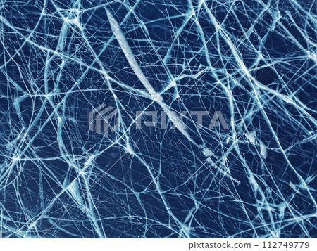 Transparent dark blue ice of frozen Baikal lake with white cracks pattern. Beautiful winter nature background. Great backdrop for your design with copy space. 112749779