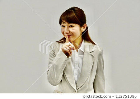 Young woman doing the "Shhh, tell me" pose Young woman doing the "Shhh, tell me" pose 112751386