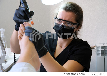 pedicure in the salon professional master takes care of cleans the foot close-up video in the process in Beauty salon trimming nails doing massage in black gloves advertising. life of a woman video. pedicure in the salon professional master takes care of cleans the foot close-up video in the process in Beauty salon trimming nails doing massage in black gloves advertising. life of a woman video. 112751443