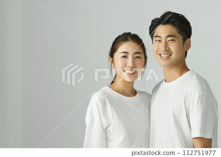 Portrait of z generation men and women wearing white t-shirts and smiling 112751977