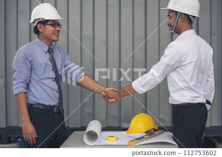 Close up warehouse worker shakehand together. Engineer man hands partnership. Diversity Coworker Men logistics Warehouse teams handshake. Multiracial Support team greeting person teamwork colleagues 112753602