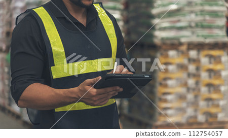 Close up Hispanic men hands using pen touch smart tablet Warehouse management logistics counting checking products on inventory shelf. Man hands worker check stock control in distribution storage 112754057