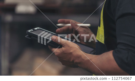 Close up Hispanic men hands using pen touch smart tablet Warehouse management logistics counting checking products on inventory shelf. Man hands worker check stock control in distribution storage Close up Hispanic men hands using pen touch smart tablet Warehouse management logistics counting checking products on inventory shelf. Man hands worker check stock control in distribution storage 112754067