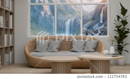 A comfortable, Scandinavian living room features a wooden coffee table and a wicker couch A comfortable, Scandinavian living room features a wooden coffee table and a wicker couch 112754763