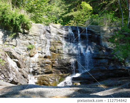 Waterfall falling through the fresh green mountains Waterfall falling through the fresh green mountains 112754842