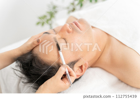 A man adjusting his eyebrows at an eyebrow salon, permanent makeup, men's eyebrow salon, and beauty eyebrow salon 112755439