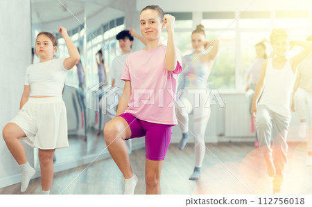 Woman teacher in background dances with students, inspects and observes skill of dancers Woman teacher in background dances with students, inspects and observes skill of dancers 112756018