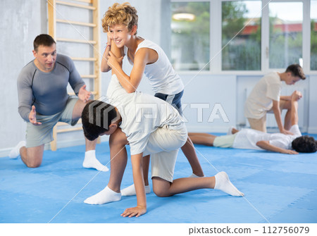 Teen boys practicing armlock in training bout during self defence course 112756079