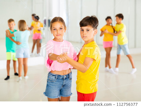 Preteen children learning to dance waltz in pairs in choreography class 112756377