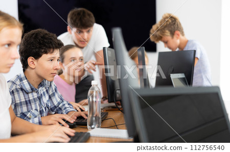 Boy student learning to work on computer in classroom Boy student learning to work on computer in classroom 112756540