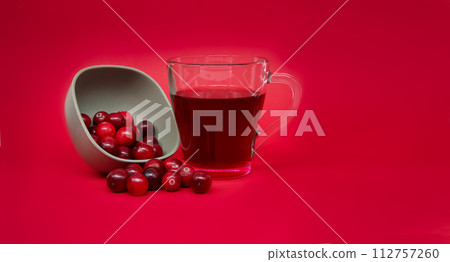 Fresh cranberries and cranberry juice against red Fresh cranberries and cranberry juice against red 112757260
