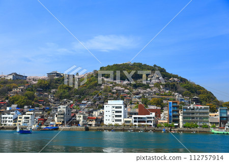 [Hiroshima Prefecture] Senkoji Park with cherry blossoms in full bloom seen from Mukaishima (Onomichi) 112757914