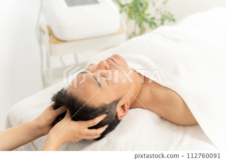 一位男士在男士美容院接受頭部水療、頭部按摩和頭皮護理治療 一位男士在男士美容院接受頭部水療、頭部按摩和頭皮護理治療 112760091